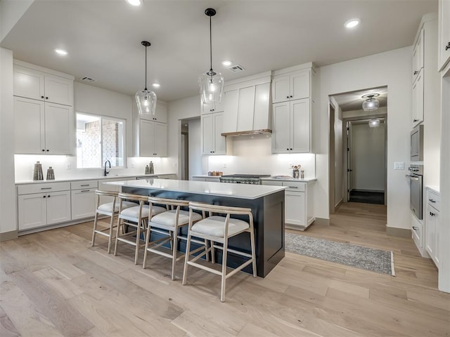 kitchen featuring a kitchen bar, white cabinetry, and a center island