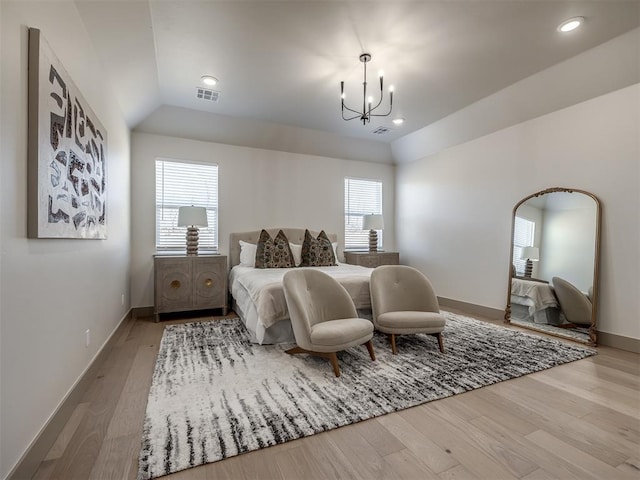 bedroom with lofted ceiling, a chandelier, multiple windows, and light hardwood / wood-style floors