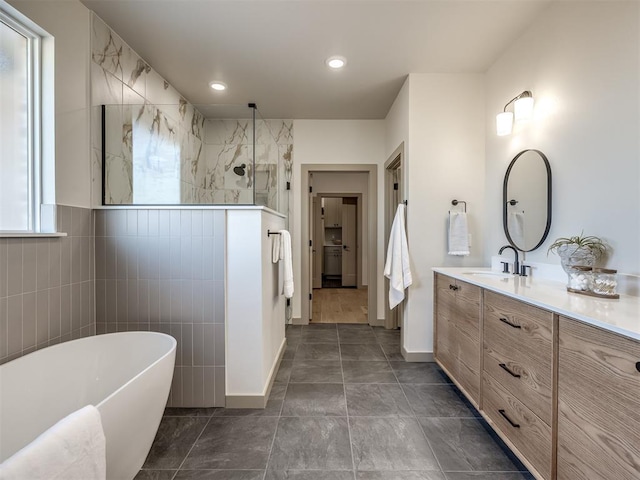 bathroom featuring tile patterned flooring, vanity, and plus walk in shower