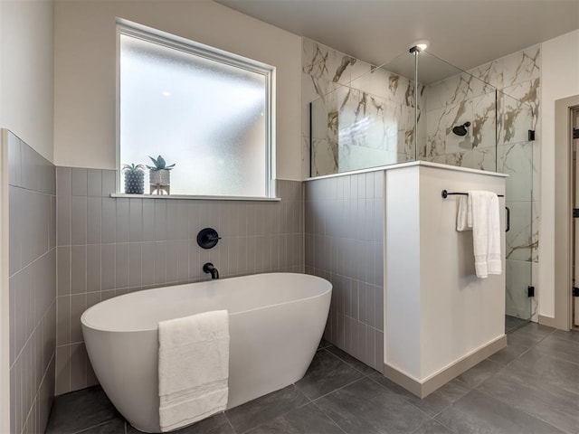 bathroom featuring tile walls and independent shower and bath