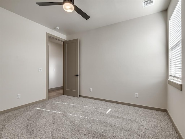 empty room featuring ceiling fan and carpet floors