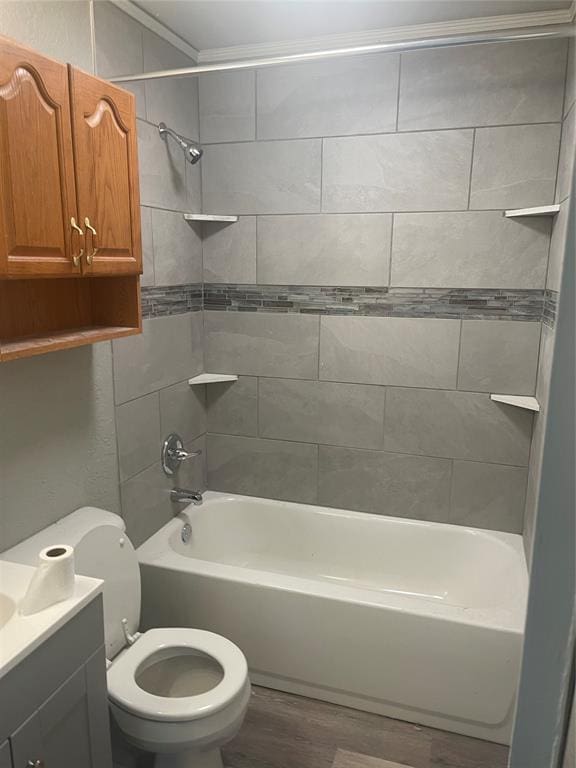 full bathroom with tiled shower / bath combo, ornamental molding, hardwood / wood-style flooring, vanity, and toilet