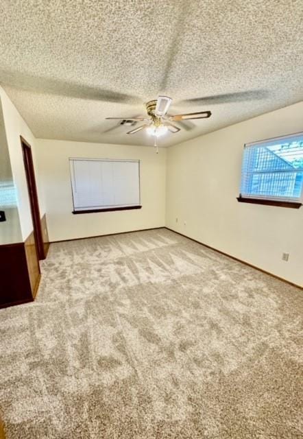 interior space with ceiling fan, carpet floors, and a textured ceiling