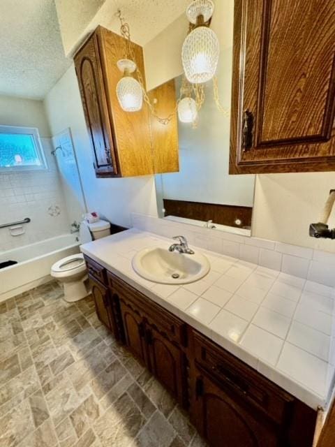 full bathroom featuring vanity, toilet, a textured ceiling, and bathing tub / shower combination