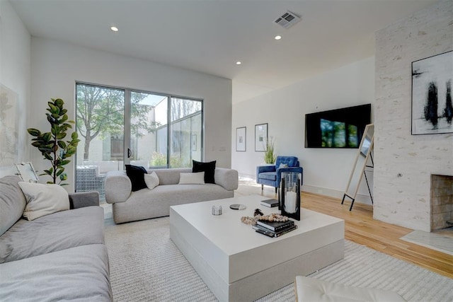 living room featuring a large fireplace and light hardwood / wood-style flooring