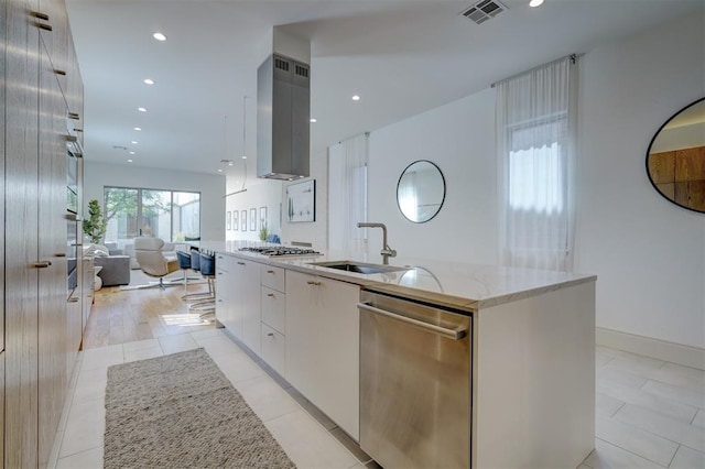 kitchen featuring exhaust hood, light tile patterned floors, dishwasher, white cabinetry, and an island with sink