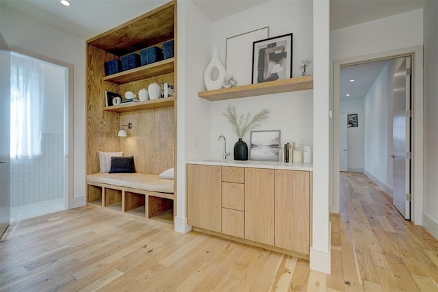 mudroom with sink and light hardwood / wood-style floors