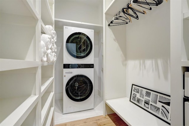 washroom featuring hardwood / wood-style floors and stacked washer and dryer