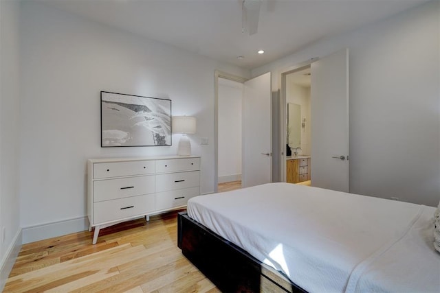 bedroom featuring light wood-type flooring, ensuite bathroom, and ceiling fan