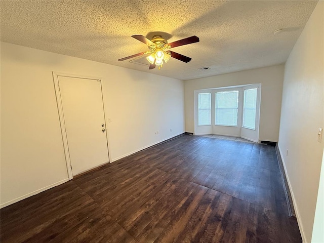 unfurnished room with a textured ceiling, ceiling fan, and dark hardwood / wood-style floors