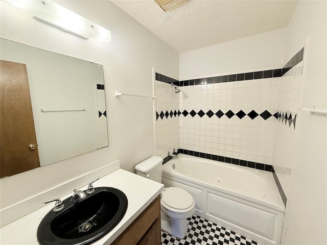 full bathroom with vanity, a textured ceiling, toilet, and tiled shower / bath