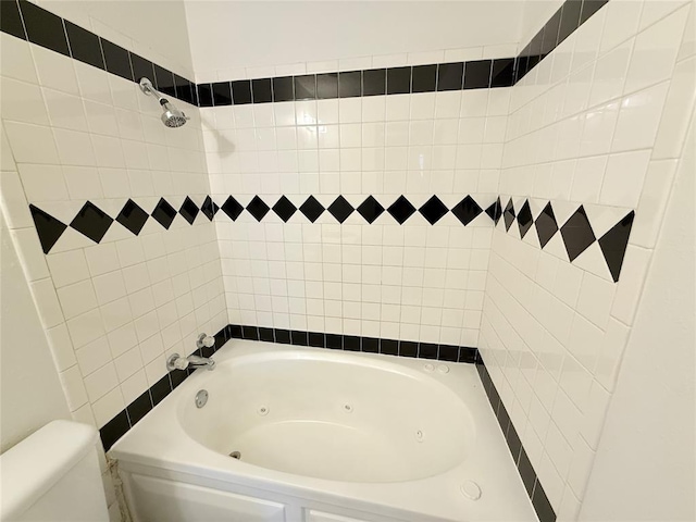 bathroom with toilet and tiled shower / bath