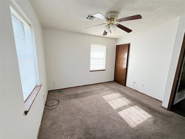 unfurnished bedroom featuring carpet, a textured ceiling, and ceiling fan