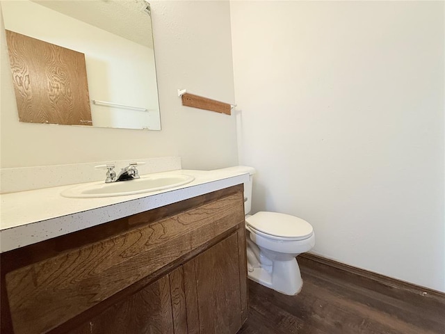 bathroom with vanity, hardwood / wood-style flooring, and toilet