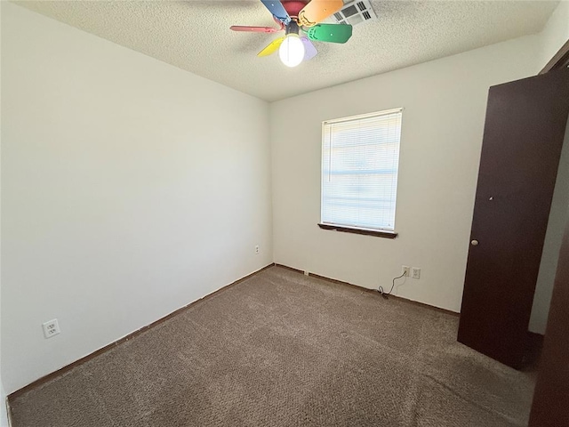 spare room with carpet flooring, ceiling fan, and a textured ceiling