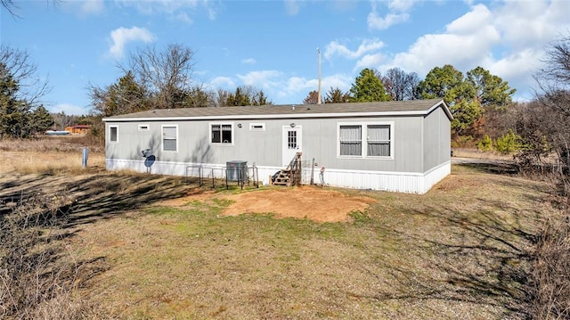 back of property with a lawn and central air condition unit