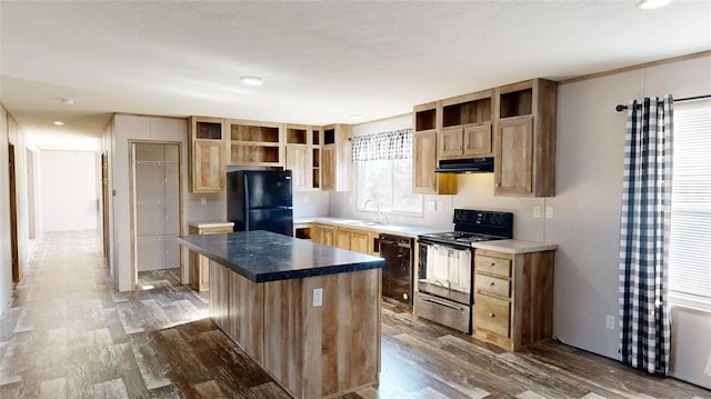 kitchen with a center island, black appliances, a kitchen breakfast bar, sink, and dark hardwood / wood-style floors