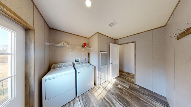 laundry area with dark hardwood / wood-style flooring, washing machine and dryer, plenty of natural light, and crown molding