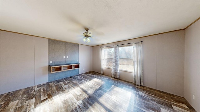 unfurnished living room with ceiling fan, dark hardwood / wood-style flooring, and ornamental molding