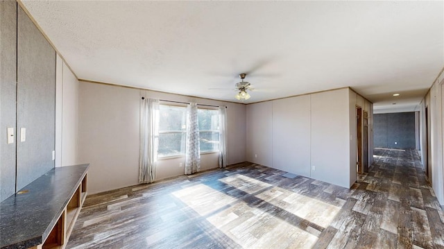 unfurnished living room featuring ceiling fan and dark hardwood / wood-style flooring