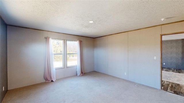 carpeted spare room featuring a textured ceiling