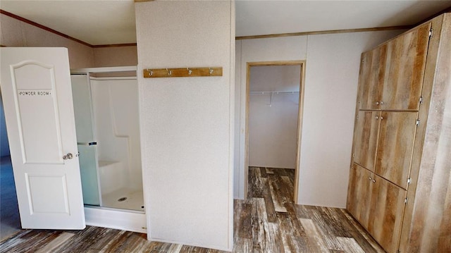 bathroom featuring a shower with door, ornamental molding, and hardwood / wood-style flooring