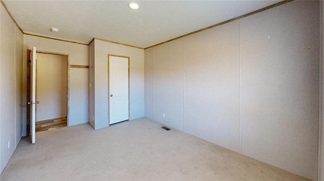 unfurnished bedroom with light colored carpet and ornamental molding