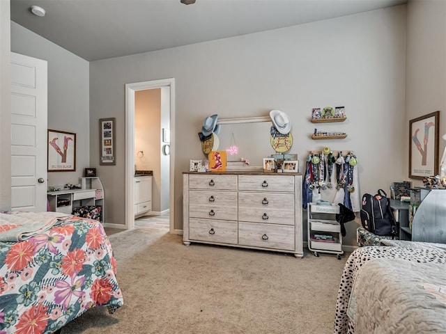 bedroom featuring ensuite bathroom and light carpet