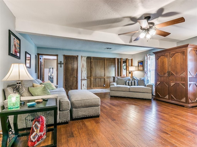 living room with wood-type flooring, a textured ceiling, and ceiling fan