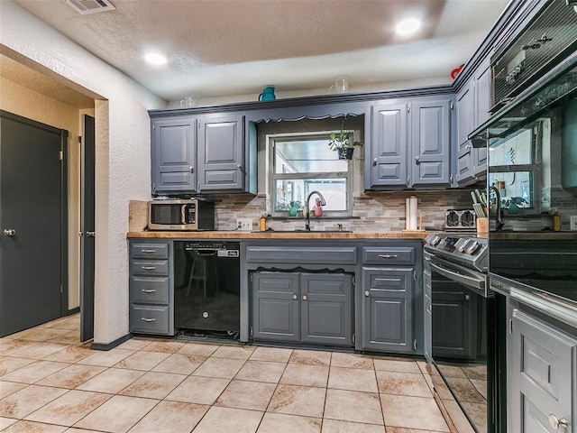 kitchen featuring backsplash, dishwasher, light tile patterned flooring, and sink