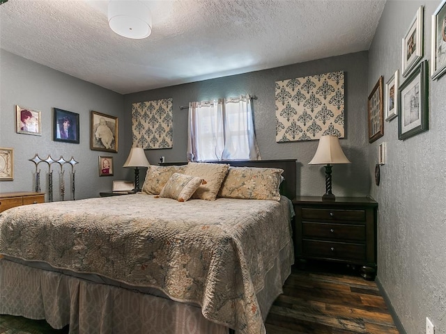 bedroom with a textured ceiling and dark hardwood / wood-style flooring