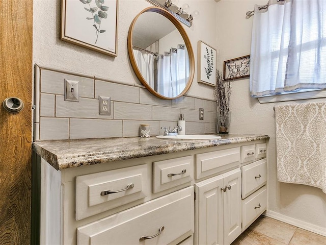 bathroom with decorative backsplash, vanity, and tile patterned flooring