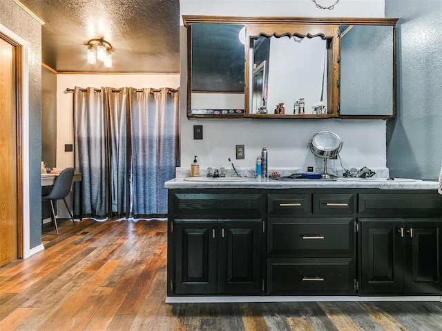 bathroom with vanity, wood-type flooring, and a textured ceiling