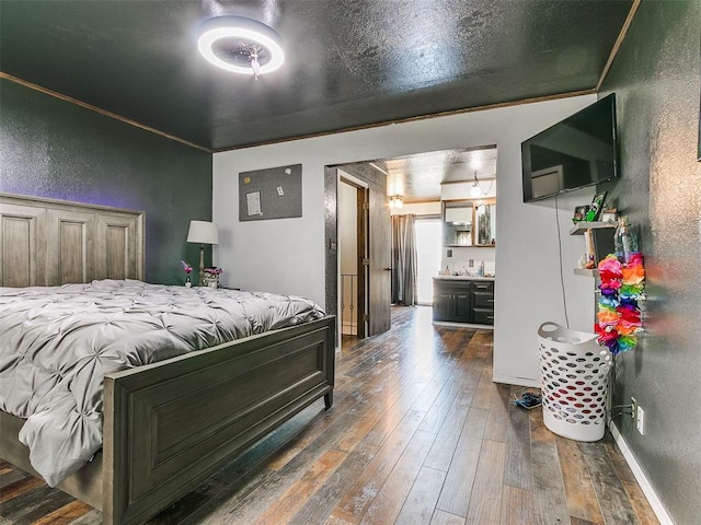 bedroom with dark hardwood / wood-style floors, ornamental molding, and sink