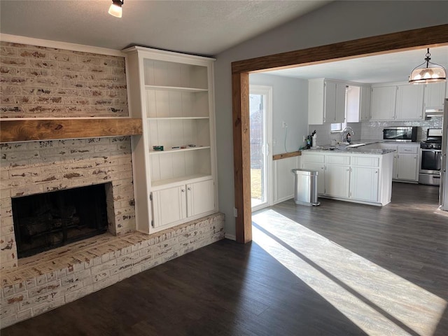 unfurnished living room with vaulted ceiling, a brick fireplace, dark wood-type flooring, and sink