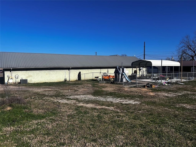 view of yard with a carport and central air condition unit