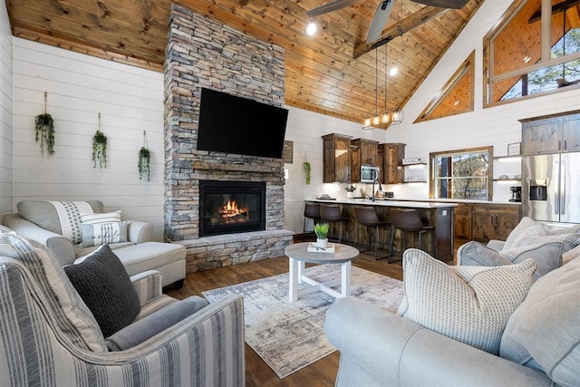 living room featuring wood ceiling, ceiling fan, beam ceiling, high vaulted ceiling, and wood walls