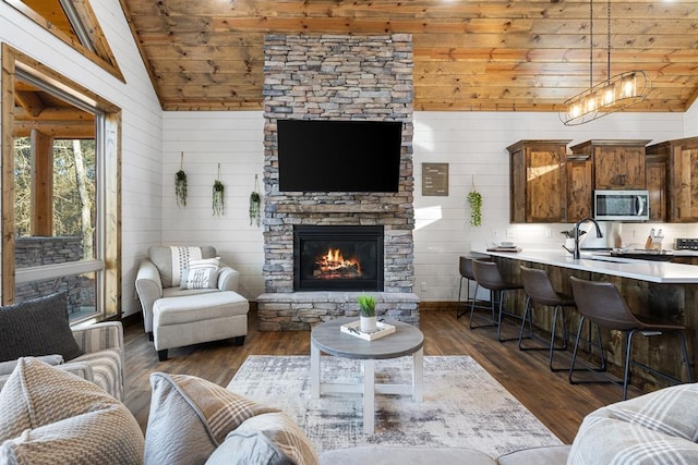 living room with dark wood-type flooring, wooden walls, sink, and wood ceiling