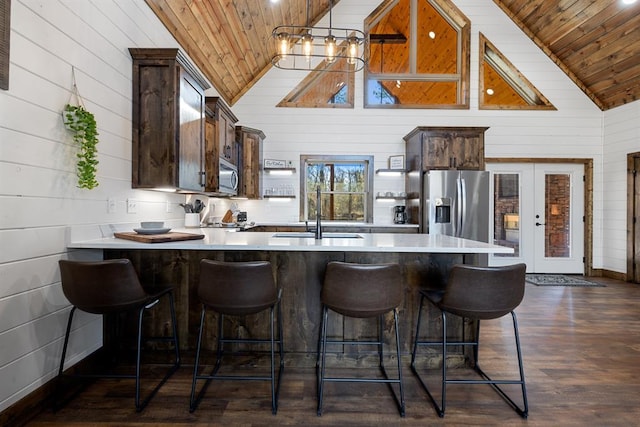 kitchen featuring appliances with stainless steel finishes, wood ceiling, wooden walls, and sink