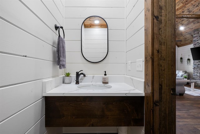 bathroom with wood walls, vanity, and hardwood / wood-style flooring