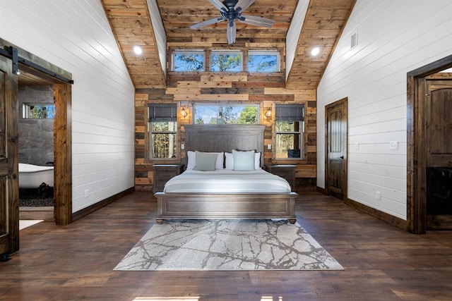 unfurnished bedroom with a barn door, dark hardwood / wood-style flooring, high vaulted ceiling, and wood ceiling