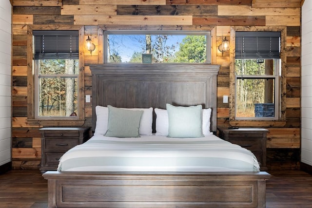 bedroom with wood walls and dark hardwood / wood-style flooring