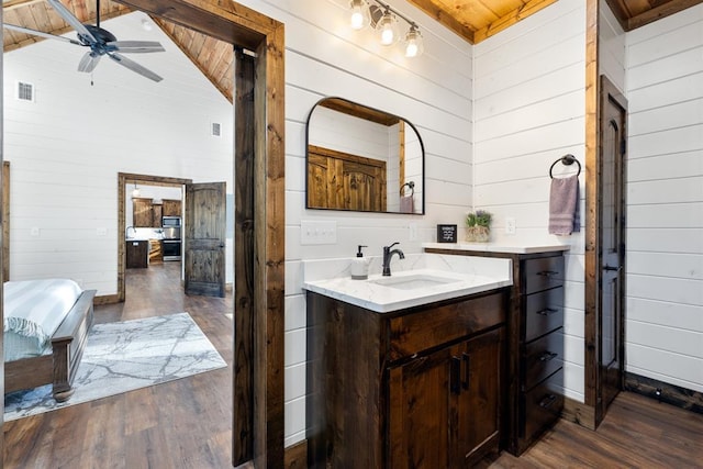 bathroom featuring wooden walls, wooden ceiling, vaulted ceiling, and hardwood / wood-style flooring