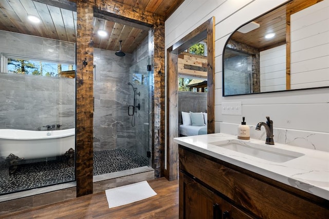 bathroom with hardwood / wood-style floors, vanity, separate shower and tub, and wooden ceiling