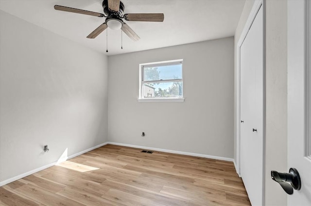 unfurnished bedroom with ceiling fan, light wood-type flooring, and a closet