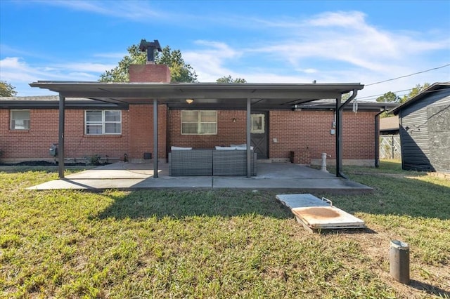 back of house with a lawn, an outdoor living space, and a patio