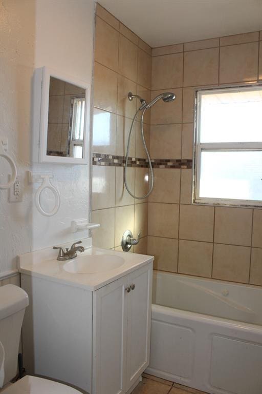 full bathroom with tile patterned flooring, vanity, toilet, and tiled shower / bath combo