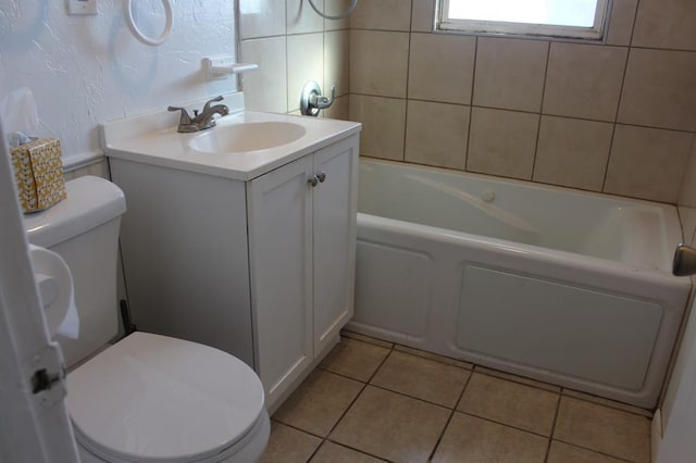 bathroom with tile patterned floors, a tub, vanity, and toilet