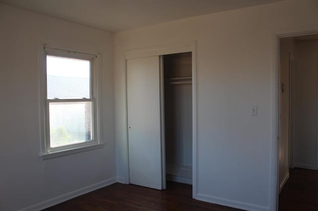 unfurnished bedroom featuring dark hardwood / wood-style floors and a closet