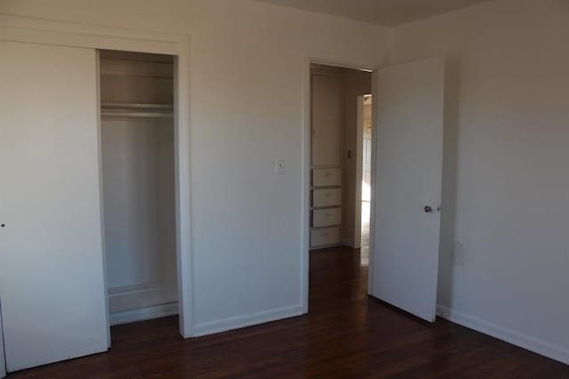 unfurnished bedroom with dark wood-type flooring and a closet